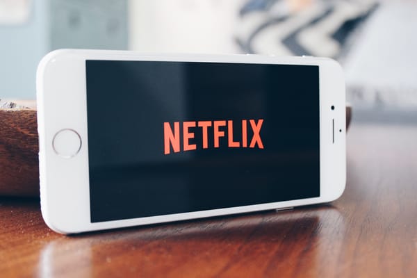 Photo of an old iPhone with the Netflix logo being displayed on the screen